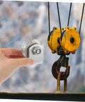 Person holding a 4-inch V-groove gate wheel near industrial pulley system.
