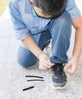 Upgrade Your Kicks With This Ultimate 78-Piece Shoe Lace End Cap Repair Kit. Get Heat Shrink Plastic Tips To Fix Tired Shoelaces Fast And Easy For Any Sneaker. Reusable DIY Accessories That Save A Buck And Look Fresh On Athletic, Casual Or Dress Shoes. boy tying sneaker laces with replacement heat shrink tips