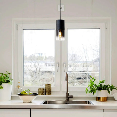 Two Pack Adjustable Black Gradient Glass Pendant Lights With Matte Black Finish above kitchen sink near plants