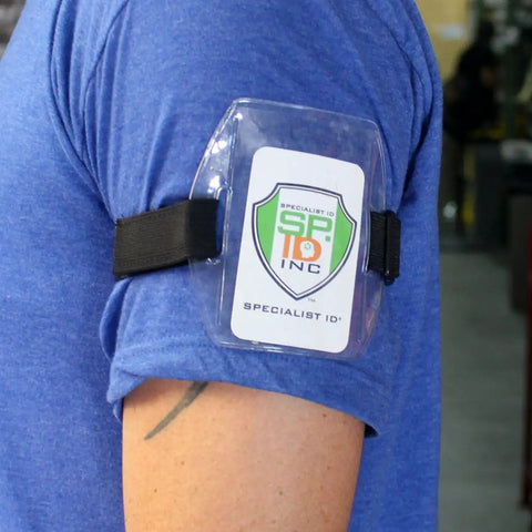 Premium Solid Durable Armband Badge Holder With Hella Secure Stretchy Strap And Easy Hook Loop Fastener For Work Credentials Cards And Passes One Size Fits on blue shirt.