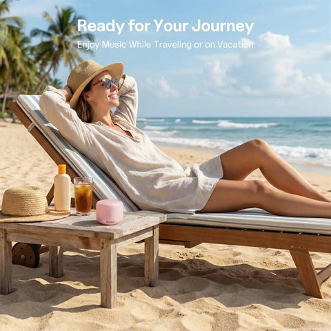 Woman on beach lounger with pink Ultra Portable Bluetooth Speaker With Strap For On The Go IPX5 Waterproof Mini Speaker.