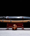 Xiuchun Dao Chinese Sabre Hand Forged Manganese Steel With Teak Wood Scabbard displayed on stand