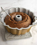 Reusable Bundt Cake Thermometer That Turns Red When Doneness Is Reached inserted in Bundt cake in pan, aluminum, silicone tip cover
