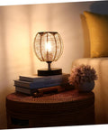 Set Of 3 Retro Rattan Woven Pendant Light Covers Boho Handwoven Natural Lamp Shades Bulb Guard Cages For Pendant Lights and Ceiling Fans Brown Home Decor displayed on a small table with a glowing light.