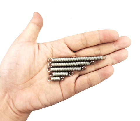 Hand-held close-up of stainless steel extension springs with hook ends; 60-piece assortment, 0.035 inch wire, 1/4 inch OD.