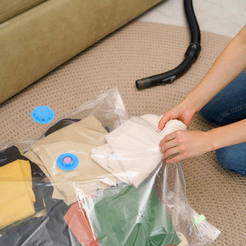 Person sealing clothes in a vacuum bag with 20 Pack Vacuum Bag Valve Plug Set for Leakproof Sealing, Tight Seal Compression Bag Fittings.