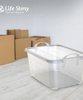 Heavy Duty Stackable Storage Bins Eighteen Pack White Plastic 55 Quart Home Organizers in a room with cardboard boxes.