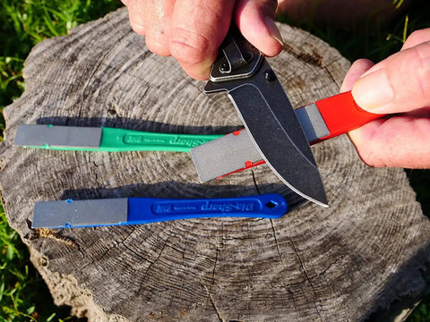 DiaSharp Diamond Mini Hone Sharpening Kit with coarse, fine, extra-fine grit stones sharpening knife on wooden stump