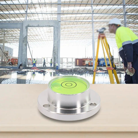 Small Horizontal Bubble Level on a workbench at a construction site with workers adjusting machinery.