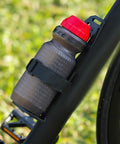 Front Fork Mounted Water Bottle Cage And Cargo Rack For Bikes with fixing strap on bicycle frame holding water bottle securely