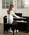 Woman playing Privia PX 870 88 Key Weighted Console Digital Piano With Tri Sensor II Scaled Hammer Action For Real Feel in living room