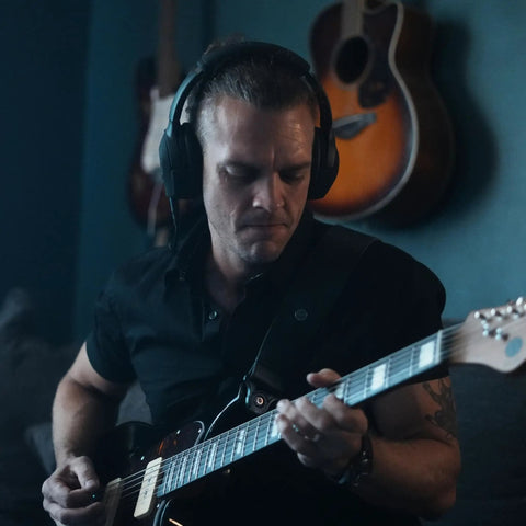 Musician using Dope Tone Wired Smart Guitar Headphone Amp With Custom Audio Drivers Noise Isolation Bluetooth Streaming And AI Powered App For Electric Acoustic And Bass Guitars