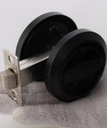 Sleek Stainless Steel Low Profile Door Knobs With Butter Smooth Nonlocking Flat Handle And Hidden Recessed Cup Shape Fast Mount Pocket Entry Handle Set Includes Black Chicago Screws For Rock Solid Grip shown from an angle in hand.
