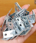 Hand holding 10 Pieces Iron Right Angle Corner Brackets For Furniture Cabinets Tables And Chairs Connectors Fasteners Hardware Accessories