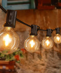 Weatherproof 50Ft Outdoor String Lights With 25 Edison Bulbs And 2 Spare LEDs, IP45 Waterproof And Shatterproof, hanging on a patio