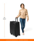 Briggs & Riley expandable spinner luggage shown with a model for scale, featuring a 29-inch softside design with four 360° wheels.