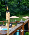 Easy Pour 12 Pack Bamboo Torch Set With Classic Weave Brown Finish Outdoor Lawn Patio Garden Lighting Weather Resistant 57 Inch Tall Decorative Torches Renewable Bamboo Spill Free Fuel Canisters installed on deck