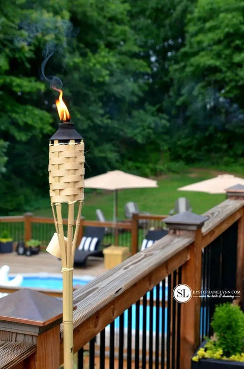 Easy Pour 12 Pack Bamboo Torch Set With Classic Weave Brown Finish Outdoor Lawn Patio Garden Lighting Weather Resistant 57 Inch Tall Decorative Torches Renewable Bamboo Spill Free Fuel Canisters installed on deck