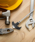 Heavy Duty Carbon Steel Tent Stakes Set with Plastic Head and Gray Remover Tool alongside tools on a wooden surface