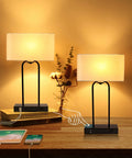 Two Pack Bedside Table Lamps With USB Ports And AC Outlet, 20 Inch Touch Control, cream fabric shade, on a wooden table.