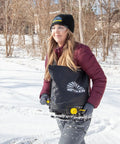 Person using Spyker 25Lb Bag Spreader With Material Viewing Window And Easy Calibration System in snowy landscape