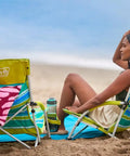 Person relaxing on beach in Utopia Breeze Lightweight Beach Chair With Cup Holder And Carry Bag For Easy Outdoor Relaxation.