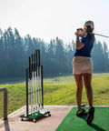 Sturdy Ten Club Golf Storage Rack Stand For Garage And Home Golf Simulator Holds Ten Clubs next to golfer at a driving range