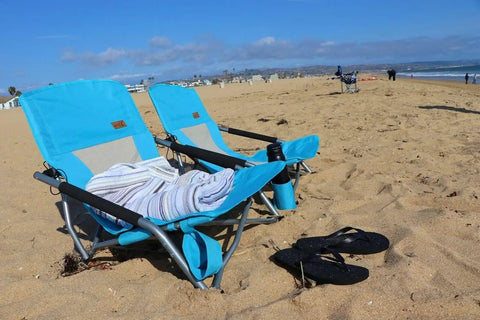 Low Profile Beach Chair 2 Pack For Adults Folding And Portable With Cup Holder And Carry Bag on sandy beach with flip flops