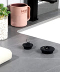 Four Piece Tub Stopper Set With Hanging Ring Rubber Drain Plugs For Tub Sink Kitchen And Bathroom In Black on grey counter