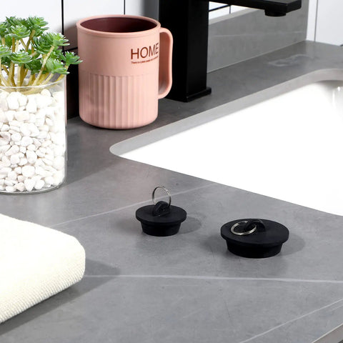 Four Piece Tub Stopper Set With Hanging Ring Rubber Drain Plugs For Tub Sink Kitchen And Bathroom In Black on grey counter