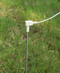 Grounding Rod Gear With 40 Ft Ground Wire For Grounded Mats Sheets Pads Wrist Bands Blankets Pillowcases Stay Grounded Indoors Stainless Steel Travel Rod For Wellness And Energy Balance placed in grass.