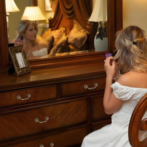 Woman sitting at wooden dresser with antique drop bail drawer pulls in bronzed finish, mirror reflection, bedroom setting