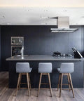 Modern kitchen with black wood peel and stick wallpaper self adhesive contact paper, featuring an island and bar stools.