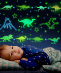 Child in a stars pajamas gazing at Glow In The Dark Dinosaur Wall Decals For Boys Room Pack Of 652 Pcs Dinosaur Wall Stickers with dinosaurs and stars