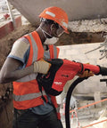 Worker using Beast 120 Volt SDS Max Corded Rotary Hammer Drill Kit With AVR Vibration Reduction on construction site wall
