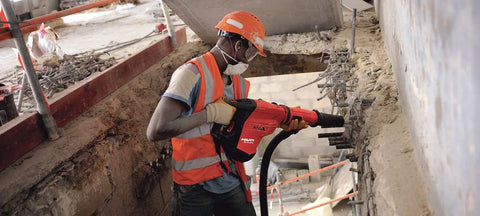 Worker using Beast 120 Volt SDS Max Corded Rotary Hammer Drill Kit With AVR Vibration Reduction on construction site wall
