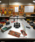Four Way Remote Control Board For DIY Robotics With Two Way Transmitter And Receiver Maker Friendly Setup To Control Two Motors 27MHz RC Module displayed in workshop