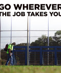 Tough As Nails 18V Cordless Airless Paint Sprayer With Advanced HEA Tech used by worker on job site, grassy area, bright daylight.