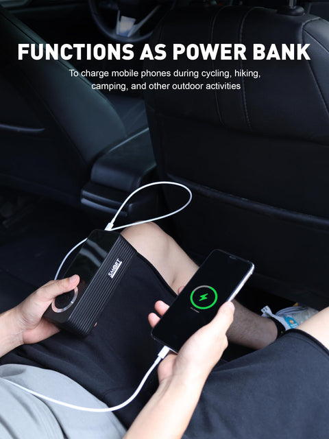 Cordless Tire Inflator With Gauge On The Go Mini Air Compressor being used as a power bank in a car, charging a smartphone