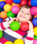 Child smiling in colorful ball pit with Play Balls for Ball Pit, Plastic Crush Proof, Phthalate & BPA Free, Assorted Colors (200 Balls).