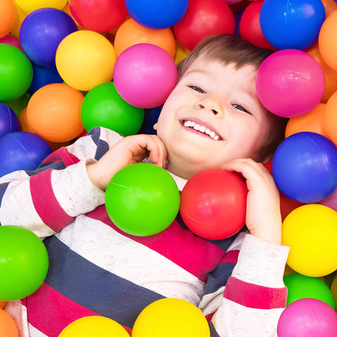 Child smiling in colorful ball pit with Play Balls for Ball Pit, Plastic Crush Proof, Phthalate & BPA Free, Assorted Colors (200 Balls).