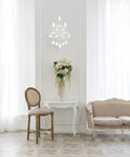 Royal Cut Clear Maria Theresa 3 Light Crystal Wall Sconce In Chrome Finish mounted above a table in an elegant living room setting.