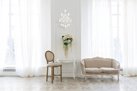 Royal Cut Clear Maria Theresa 3 Light Crystal Wall Sconce In Chrome Finish mounted above a table in an elegant living room setting.