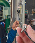 Technician holding M6x20 Nickel Plated Crown Head Rack Screws And Cage Nuts Kit With Washers near a control panel installation.