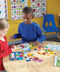 Children playing with Shapes Dont Bug Me Geometry Activity Set With 136 Pieces For Kids Ages 5 And Up in a classroom setting.