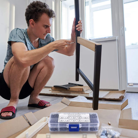 Person assembling furniture with 720 Pcs M3 Hex Socket Cap Bolts Screws Assortment Kit in foreground, DIY project setting