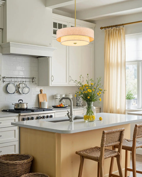18 Inch Modern Drum Chandelier 4 Light Two Tier Linen Pendant With Brushed Gold Canopy over kitchen island with white cabinetry.