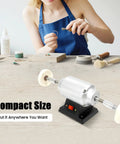 Slick Heavy Duty Workhorse Small Bench Buffing Grinder And Polishing Lathe Machine For Dental Lab With High Speed 3000Rpm Motor And Built In Lamp Plus Quiet Vacuum Extraction Pipe 110V 60Hz on a workspace with jewelry tools.