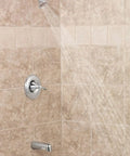 Oil Rubbed Bronze Tub And Shower Valve Trim Kit With Posi-Temp Finish, installed in bathroom wall, with valve and showerhead