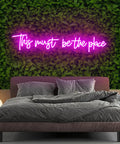 Pink 25x11 Inch Neon Sign LED Neon Lights For Bedroom Wall Decor "This Must Be The Place" above a bed with green wall